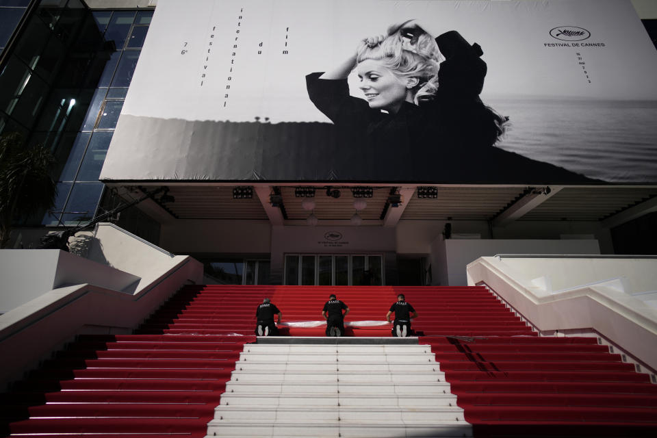 Workers roll out the red carpet for the 76th international film festival, Cannes, southern France, Tuesday, May 16, 2023. The Cannes film festival runs from May 16 until May 27 2023. (AP Photo/Daniel Cole)