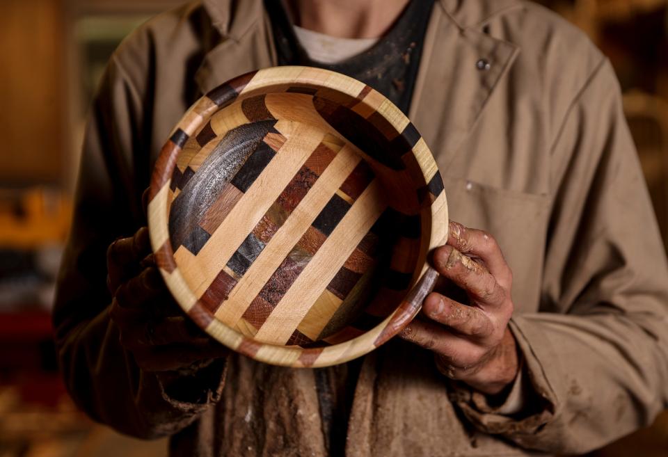 Reeve Carter holds a bowl he created using various types of wood.