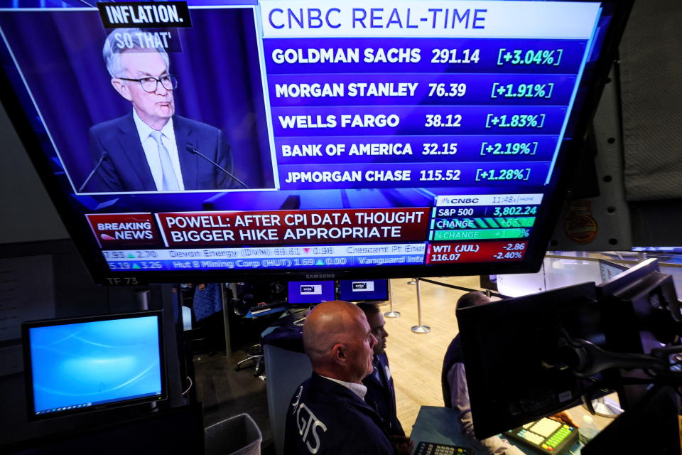 Traders work, as Federal Reserve Chair Jerome Powell is seen delivering remarks on a screen, on the floor of the New York Stock Exchange (NYSE) in New York City, U.S., June 15, 2022.  REUTERS/Brendan McDermid