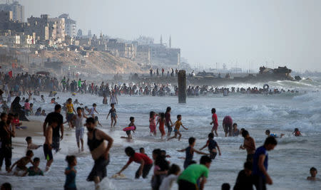 Palestinians swim to cool off in the Mediterranean Sea off the coast of the northern Gaza Strip July 13, 2018. REUTERS/Mohammed Salem