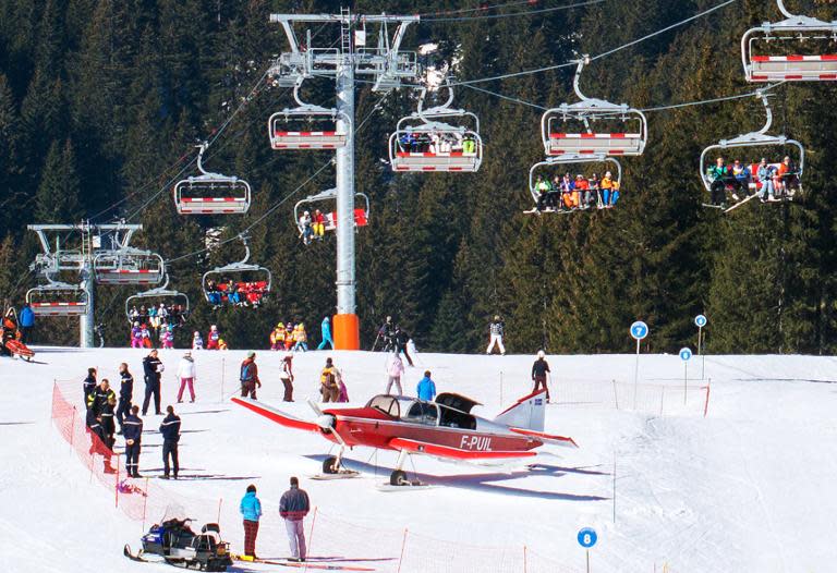 People gather around an airplane after it made an emergency landing on a ski slope in the French Alpine ski resort of Avoriaz, March 12, 2015