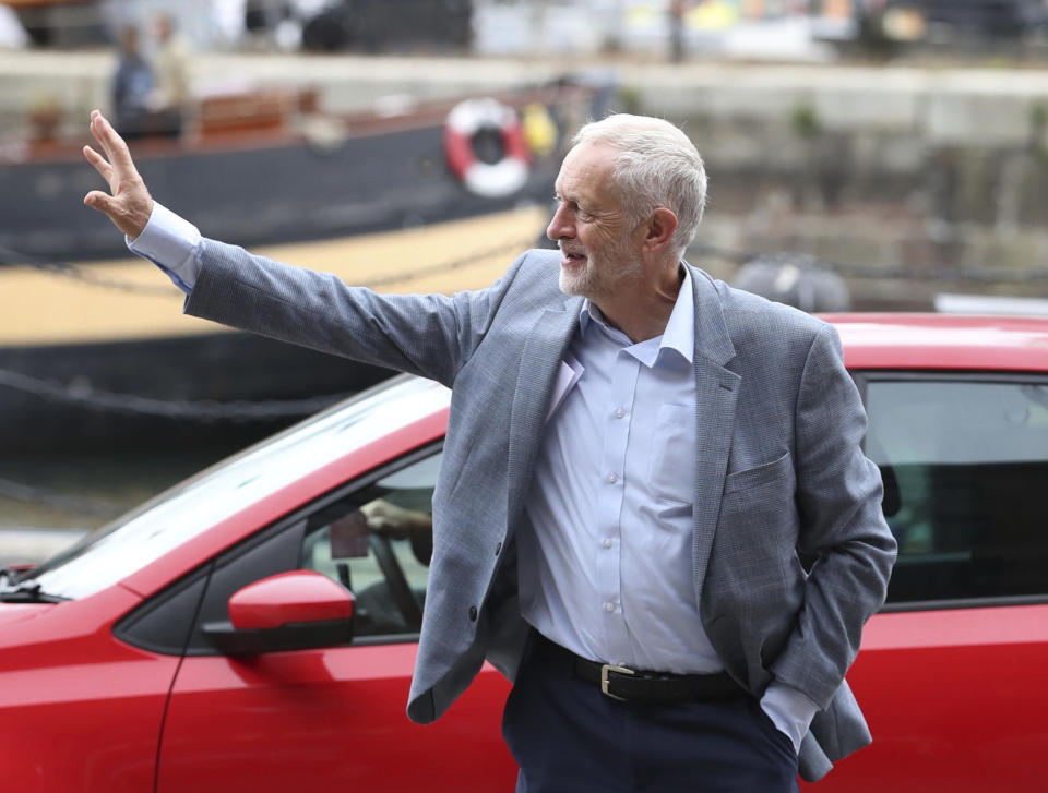 Britain's Labour Party leader Jeremy Corbyn, waves to supporters outside the International Slavery Museum at the Royal Albert Dock in Liverpool, England, as he arrives in the city for his party's annual conference, Saturday Sept. 22, 2018. The annual Labour Party conference includes a weekend of full of various rallies and meetings, with thousands of people expected to greet party leaders. (Peter Byrne/PA via AP)