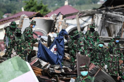 Soldiers in face masks clambered over the giant mounds of mud, brick and cement in the search for quake victims