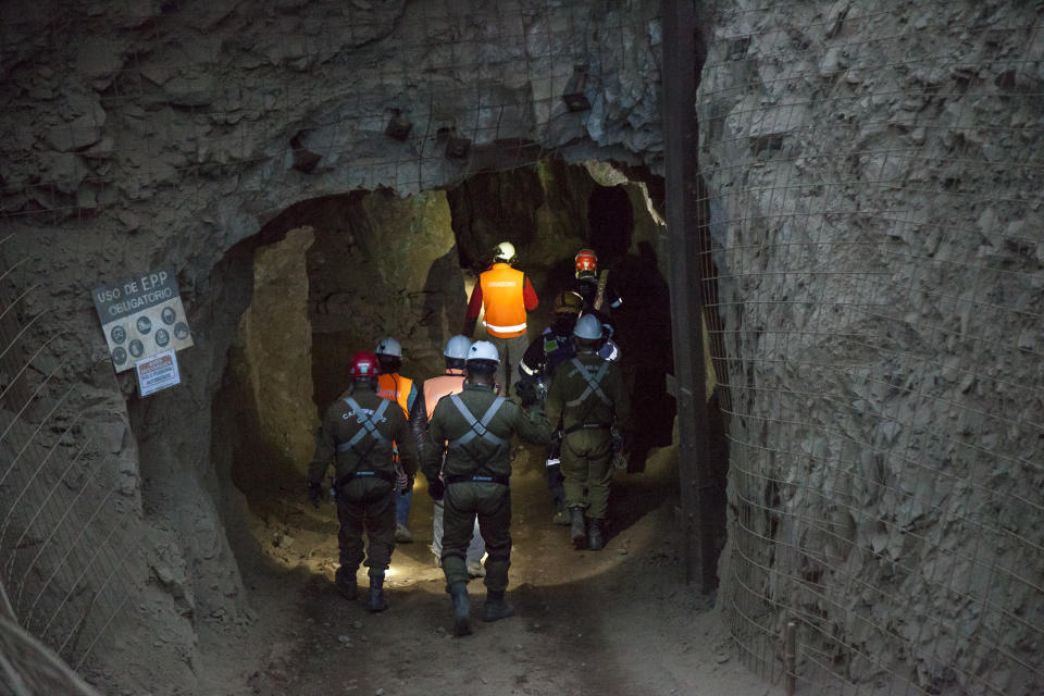 In this photo provided by the regional government of Antofagasta, men enter the San José mine to work on the rescue of three Bolivian miners trapped deep underground since the night before when it collapsed in Tocopilla, Chile, Friday, June 14, 2019. Local authorities confirmed that the men are alive. (Ricardo Rodriguez/Intendencia de Antofagasta via AP)