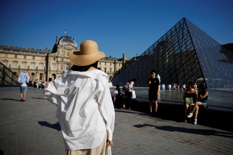 A tourist stands in front of the glass pyramid of the Louvre museum in Paris, France, June 15, 2022.<span class="copyright">Sarah Meyssonnier—Reuters</span>