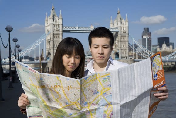 Tourists reading a map in front of London's Tower Bridge