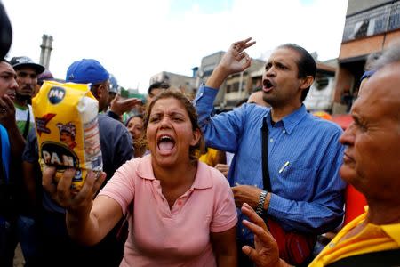 A woman shows a flour package outside a supermarket as they shout slogans over food shortage in Caracas, Venezuela, June 11, 2016. REUTERS/Ivan Alvarado/File Photo