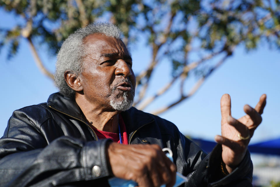 Lovia Primous, 67, speaks with some of his friends at the Ozanam Manor temporary housing for people 50 and up seeking permanent housing, Monday, Jan. 24, 2022, in Phoenix. A stroke started the 67-year-old Army veteran on his downward spiral, costing him his job and forcing him to sleep in his Honda Accord. "Life has been hard," said Primous, who grew up on in a once- segregated African American neighborhood of south Phoenix. "I'm just trying to stay positive." (AP Photo/Ross D. Franklin)