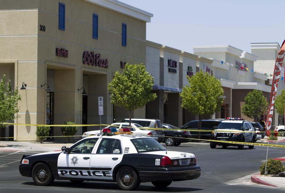 Metro Police patrol cars are used to block off access to CiCi's Pizza after a shooting in Las Vegas June 8, 2014. Two armed suspects shouting "this is a revolution" opened fire and wounded two Las Vegas Metropolitan police officers eating lunch in the pizza parlour on Sunday, then shot and killed a civilian inside a nearby Wal-Mart store before killing themselves, police said. REUTERS/Las Vegas Sun/Steve Marcus (UNITED STATES - Tags: CRIME LAW TPX IMAGES OF THE DAY)