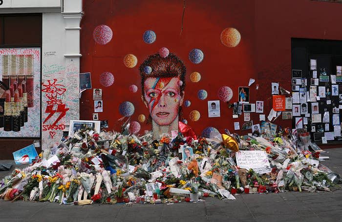 flowers and letters left to david bowie's memory at a shrine