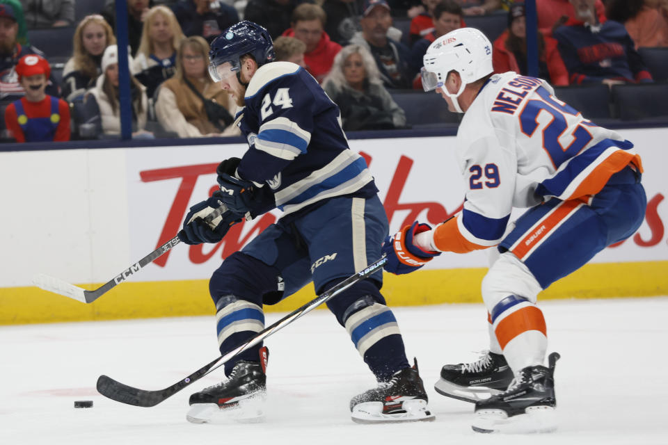 Columbus Blue Jackets' Mathieu Olivier, left, keeps the puck away from New York Islanders' Brock Nelson during the first period of an NHL hockey game Saturday, Oct. 28, 2023, in Columbus, Ohio. (AP Photo/Jay LaPrete)