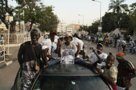 Supporters of the Gambian President Adama Barrow celebrate the partial results that give the lead to their candidate during the counting ballots in Gambia's presidential election, in Banjul, Gambia, Sunday, Dec. 5, 2021. Election officials in the West African nation of Gambia have started counting marble votes after polls closed for the first presidential election in decades that does not include former dictator Yahya Jammeh as a candidate. (AP Photo/Leo Correa)