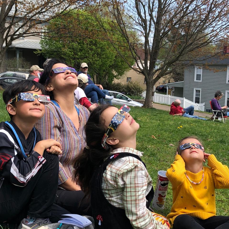 Amanda Joubert and her children Emmett, Ella and Fiona watch the solar eclipse from the Staunton Public Library lawn on April 8, 2024.