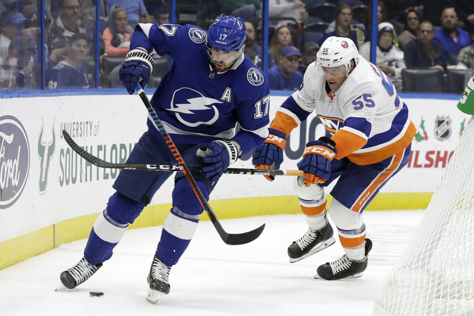 Tampa Bay Lightning left wing Alex Killorn (17) kicks the puck away from New York Islanders defenseman Johnny Boychuk (55) during the second period of an NHL hockey game Monday, Dec. 9, 2019, in Tampa, Fla. (AP Photo/Chris O'Meara)