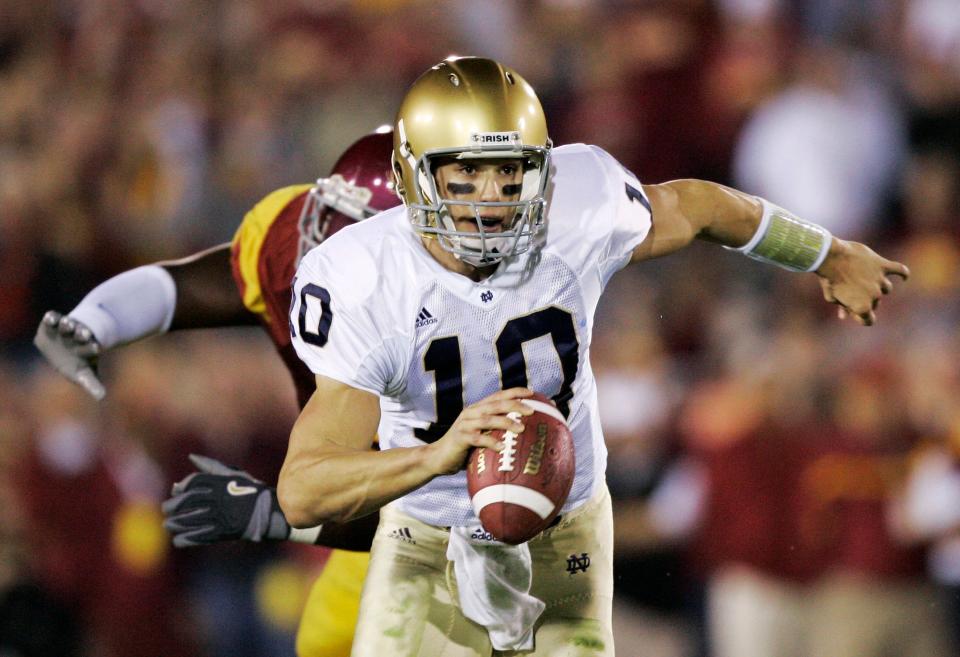 Notre Dame quarterback Brady Quinn (10) scrambles as he chased by a USC defender during the 2006 ND-USC matchup in Los Angeles.