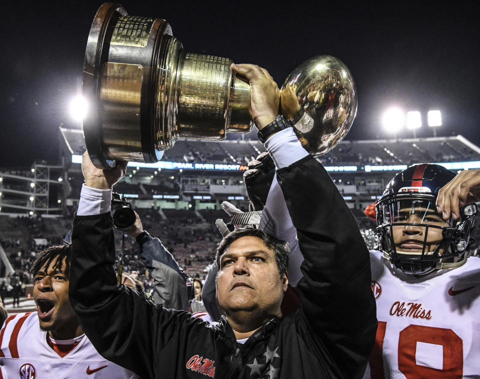 Mississippi interim coach Matt Luke holds the Golden Egg trophy following the team’s 31-28 win over Mississippi State on Thursday. (Bruce Newman/The Oxford Eagle via AP)