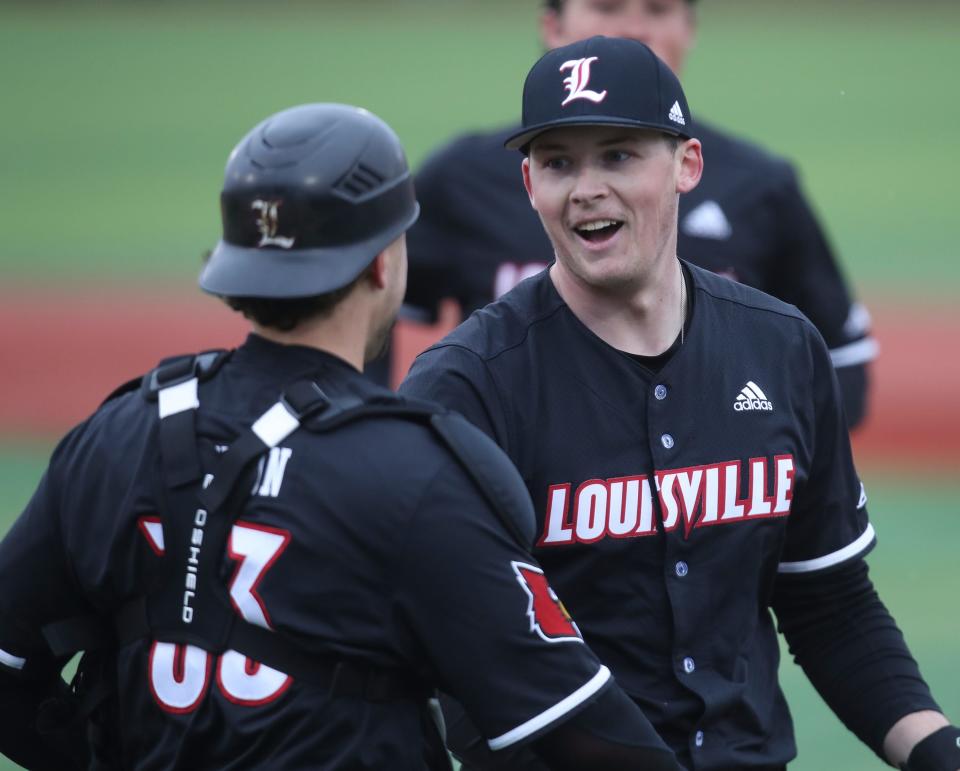 Ryan Hawks is congratulated by teammates as he comes to the dugout during U of L's opening day on Feb. 17, 2023.