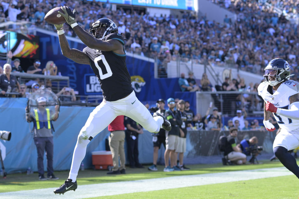 Jacksonville Jaguars wide receiver Calvin Ridley (0) makes a touchdown catch in the end zone past Tennessee Titans safety Amani Hooker, right, during the first half of an NFL football game, Sunday, Nov. 19, 2023, in Jacksonville, Fla. (AP Photo/Phelan M. Ebenhack)