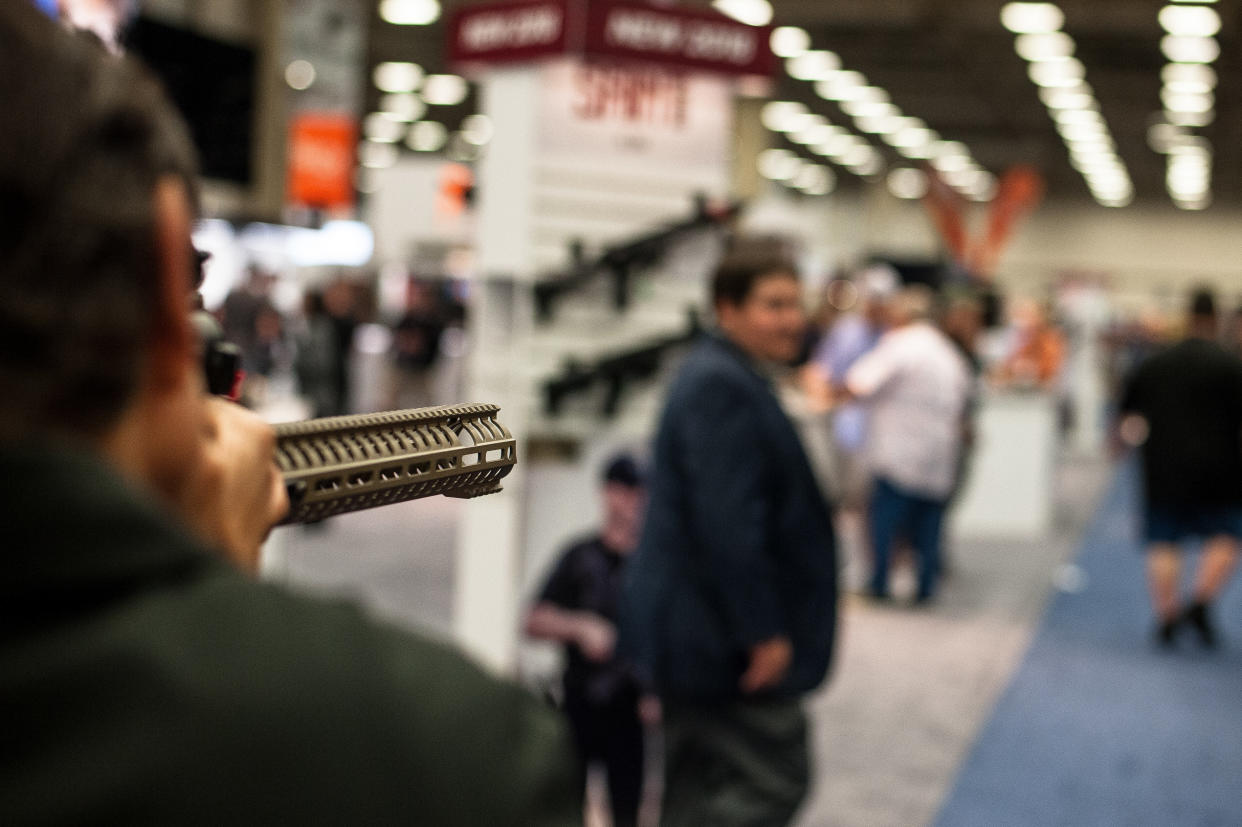 Avi Katz shoulders a display weapon to test out a scope at the annual NRA meeting in Dallas, TX. (Photo: Joseph Rushmore for HuffPost)