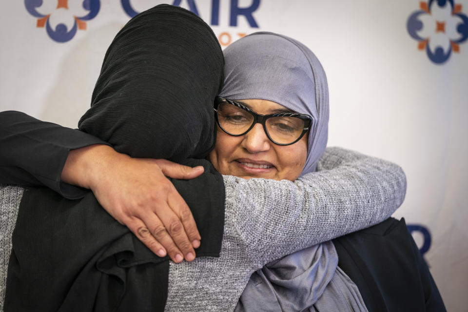 Aida Shyef Al-Kadi, right, of St. Louis Park, got a hug from Asma Mohammed, advocacy director at Reviving the Islamic Sisterhood for Empowerment, after a press conference at CAIR-MN headquarters in Minneapolis on Tuesday, December 17, 2019. Al-Kadi reached a settlement with Ramsey County for $120,000 after claiming religious discrimination after being forced to remove her hijab for a booking photo and go without a hijab for a time while in jail. (Leila Navidi/Star Tribune via AP)