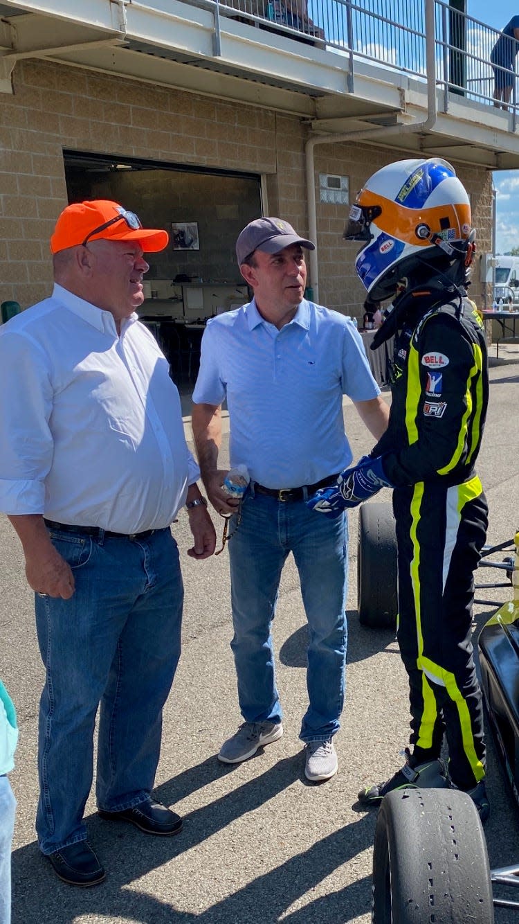 Formula 3 driver Max Esterson of Palm Beach talks with race car owner Chip Ganassi and Esterson's father, Robin.