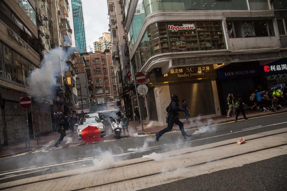 Riot police deploy flash bangs as they clear protesters from a road during a rally against a new national security law in Hong Kong on July 1, 2020, on the 23rd anniversary of the city's handover from Britain to China. - Hong Kong police made the first arrests under Beijing's new national security law on July 1 as the city greeted the anniversary of its handover to China with protesters fleeing water cannon. (Photo by DALE DE LA REY / AFP) (Photo by DALE DE LA REY/AFP via Getty Images)