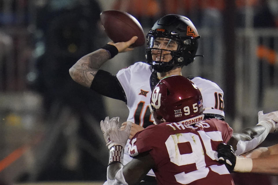 Oklahoma State quarterback Shane Illingworth (16) throws under pressure from Oklahoma defensive lineman Isaiah Thomas (95) during the first half of an NCAA college football game in Norman, Okla., Saturday, Nov. 21, 2020. (AP Photo/Sue Ogrocki)