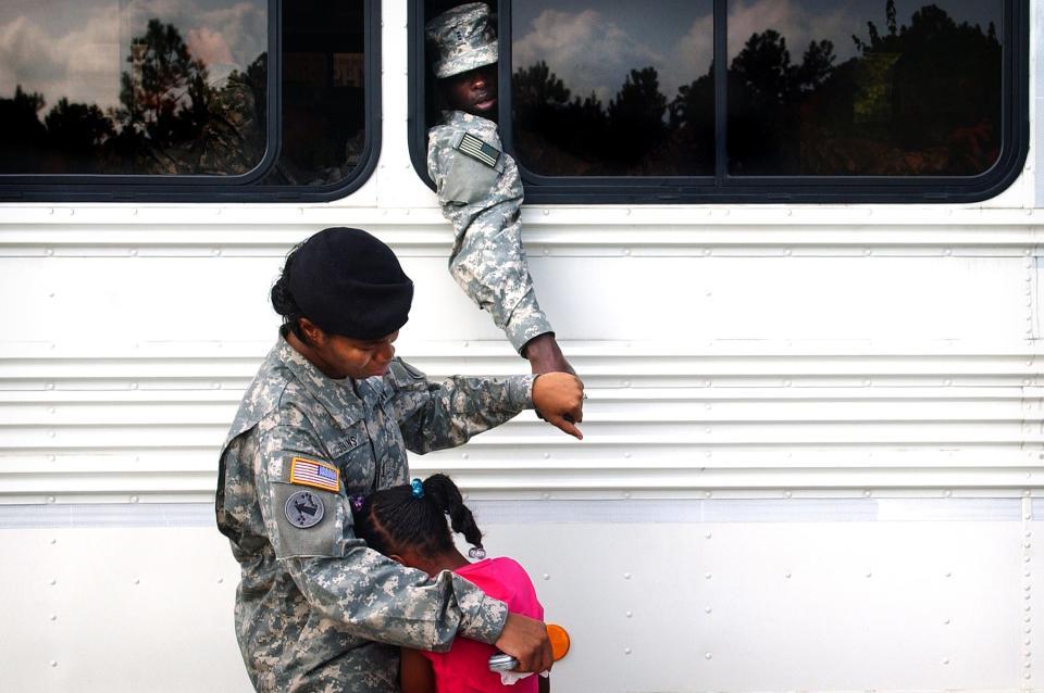 Capt. Shelia Jenkins comforts her daughter, Khadyajah, 7, while holding the hand of her husband, Chief Warrant Officer Claude Jenkins, one of about 250 paratroopers from the 82nd Airborne Division Sustainment Brigade that are departing for a deployment to Iraq, Wednesday, Aug. 23, 2006, in Fort Bragg, N.C.