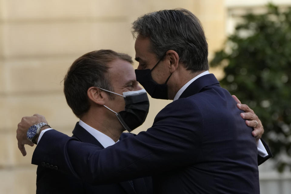 French President Emmanuel Macron, left, welcomes Prime Minister Kyriakos Mitsotakis Tuesday, Sept. 28, 2021 at the Elysee Palace in Paris. The leaders of Greece and France are expected to announce a major, multibillion-euro deal in Paris on Tuesday involving the acquisition by Greece of at least six French-built warships, Greek state ERT TV reported. (AP Photo/Francois Mori)