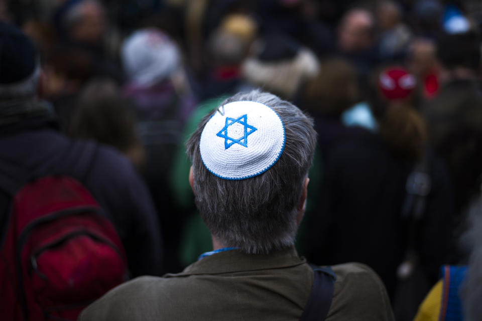 -File- In this Wednesday, April 25, 2018 file photo, a man wears a Jewish skullcap, as he attends a demonstration against an anti-Semitic attack in Berlin. The Department for Research and Information on Anti-Semitism Berlin, or RIAS documented 410 incidents in Berlin, more than two a day, in the first half of 2020, including physical attacks, property damage, threats, harmful behavior and anti-Semitic propaganda. (AP Photo/Markus Schreiber, File)