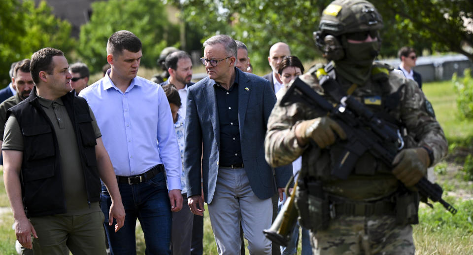 Anthony Albanese walks with a group of people and armed guard in Ukraine