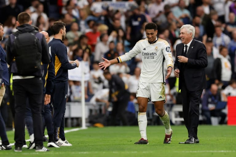 El entrenador del Real Madrid Carlo Ancelotti (derecha) bromea con el delantero Jude Bellingham tras la victoria del equipo frente al Cádiz en la 34ª jornada del campeonato español, en el Estadio Santiago Bernabéu de Madrid el 4 de mayo de 2024 (OSCAR DEL POZO)