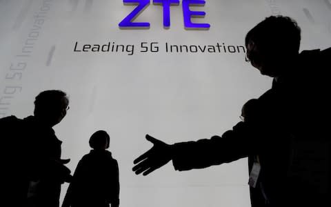  Visitors pass in front of the Chinese telecoms equipment group ZTE Corp - Credit: Reuters