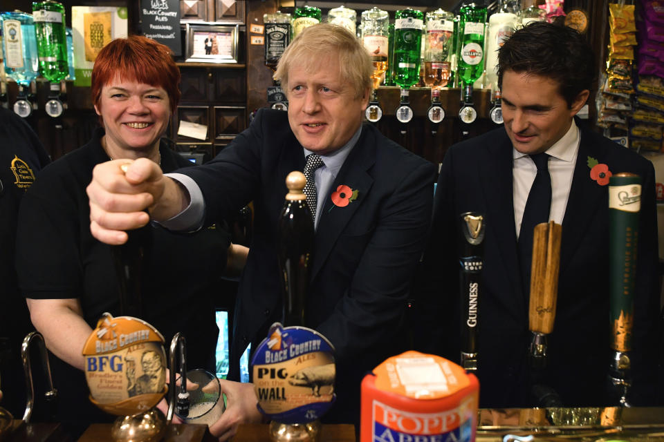 Britain' Prime Minister Boris Johnson, centre, pours a pint of beer, as he meets with military veterans at the Lych Gate Tavern in Wolverhampton, England, Monday, Nov. 11, 2019 as part of the General Election campaign trail. Britain goes to the polls on Dec. 12. (Ben Stansall/Pool Photo via AP)