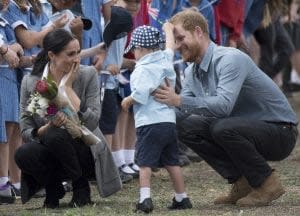 哈利王子與夫人在2018年10月17日抵達澳大利亞機場時遇到一名唐氏症的小男孩。(圖/美聯社)