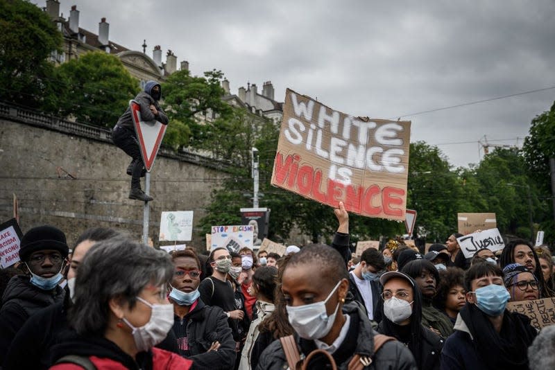 People take part in a rally on June 9, 2020, in Geneva, during a demonstration against racism and police brutality in the wake of the death of George Floyd, an unarmed black man killed while apprehended by police in Minneapolis.