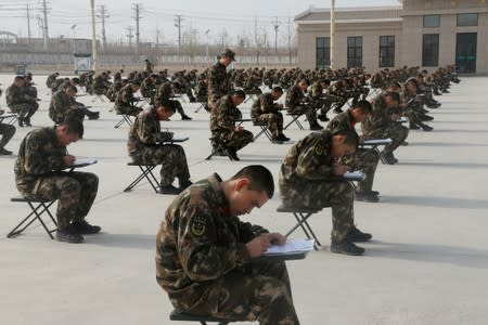 FILE PHOTO: New recruits of paramilitary police take part in a political education theory assessment in Kashgar