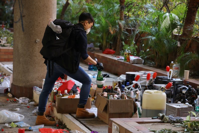 Police and firefighting personnel move Molotov cocktails, flammable materials and liquids into a corner, inside the Hong Kong Polytechnic University (PolyU) in Hong Kong, China