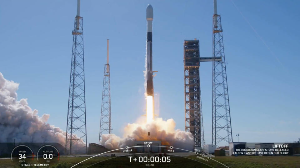 a black-and-white spacex falcon 9 rocket launches into a blue sky.