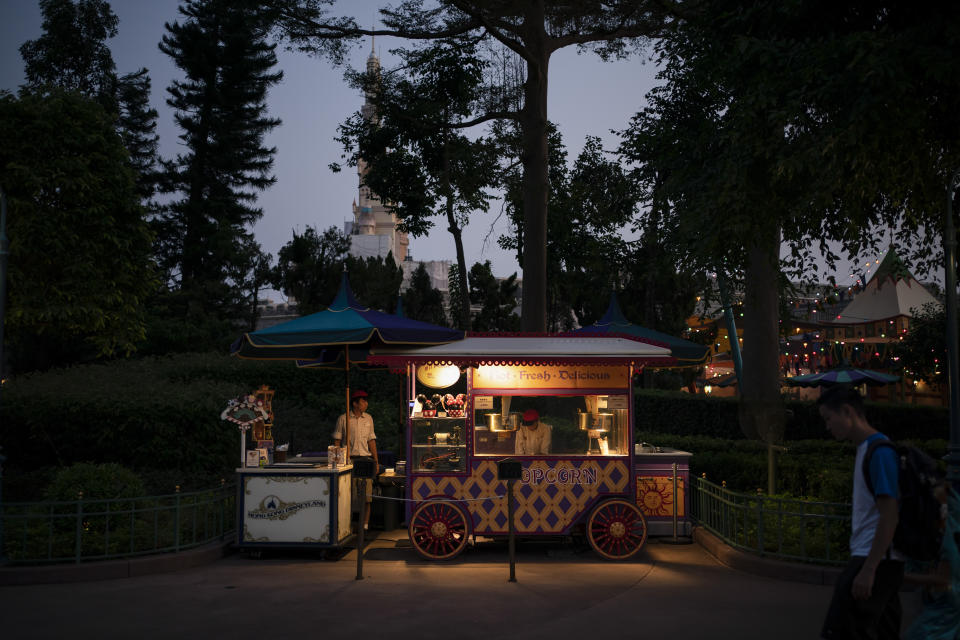 In this Oct. 11, 2019 photo, Popcorn sellers wait for customers at Hong Kong Disneyland in Hong Kong. The body-blow of months of political protests on Hong Kong’s tourism is verging on catastrophic for one of the world’s great destinations. Geared up to receive 65 million travelers a year, the city’s hotels, retailers, restaurants and other travel-oriented industries are suffering. But some intrepid visitors came specifically to see the protests and are reveling in deep discounts and unusually short lines at tourist hotspots.(AP Photo/Felipe Dana)