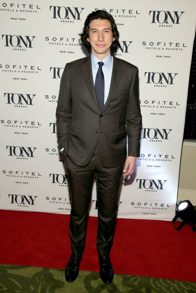 Adam Driver poses on the red carpet at the Tony Awards. He is wearing a formal suit with a tie