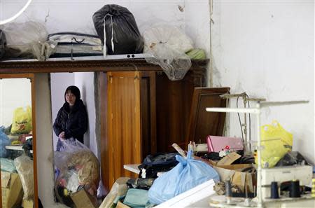 Shen Jianhe looks on as police officers conduct a check at the Shen Wu textile factory in Prato December 9, 2013. REUTERS/Stefano Rellandini