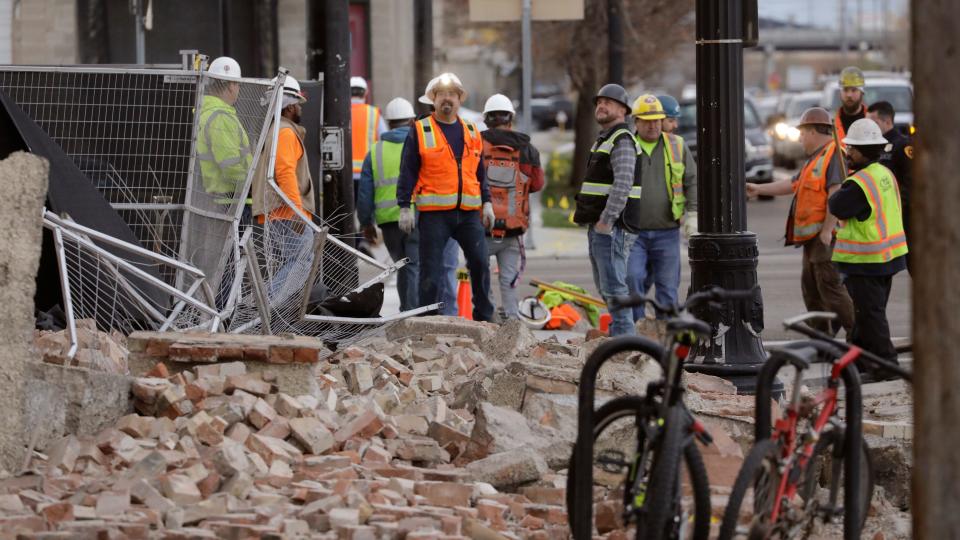 Construction workers look at the rubble from a building after an earthquake March 18, 2020, in Salt Lake City.