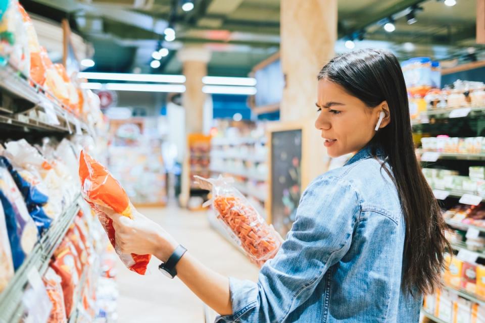 Person in a retail setting observing packaging information.