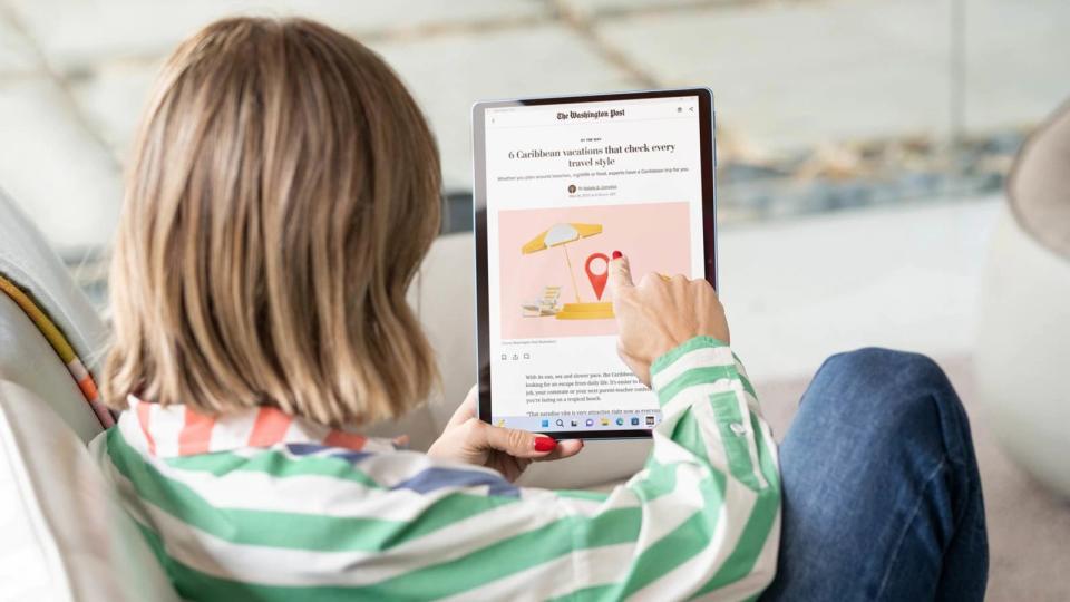 Microsoft Surface Pro 9 review: woman reading the news on a tablet