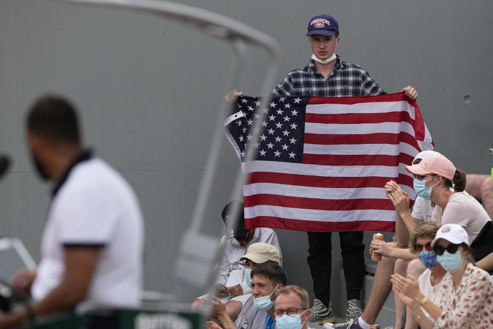 A United States fan holds up the American flag as he watches United States' John Isner play against Serbia's Filip Krajinovic on day four of the French Open tennis tournament at Roland Garros in Paris, France, Wednesday, June 2, 2021. (AP Photo/Michel Euler)