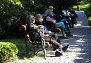 People wearing face masks for protection against the coronavirus, sit in a public garden in Ankara, Turkey, Sunday, May 24, 2020, during a four-day curfew declared by the government in an attempt to control the spread of coronavirus. Turkey's senior citizens were allowed to leave their homes for a third time as the country continues to ease some coronavirus restrictions. (AP Photo/Burhan Ozbilici)