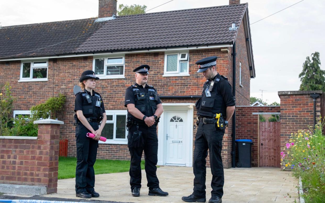Police at the home in Woking where the body of a 10 year old girl was discovered