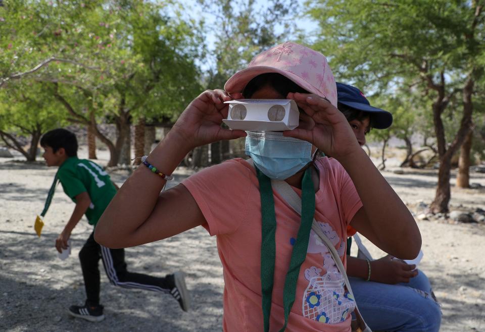 Melissa Callente looks through a pair of cardboard binoculars while visiting the La Quinta Cove Oasis with other students from Las Palmitas Elementary School during a field trip with members of the Friends of the Desert Mountains in La Quinta, Calif., May 10, 2023. 