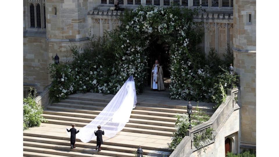 Meghan Markle walking up the steps at St George's Chapel in her wedding dress